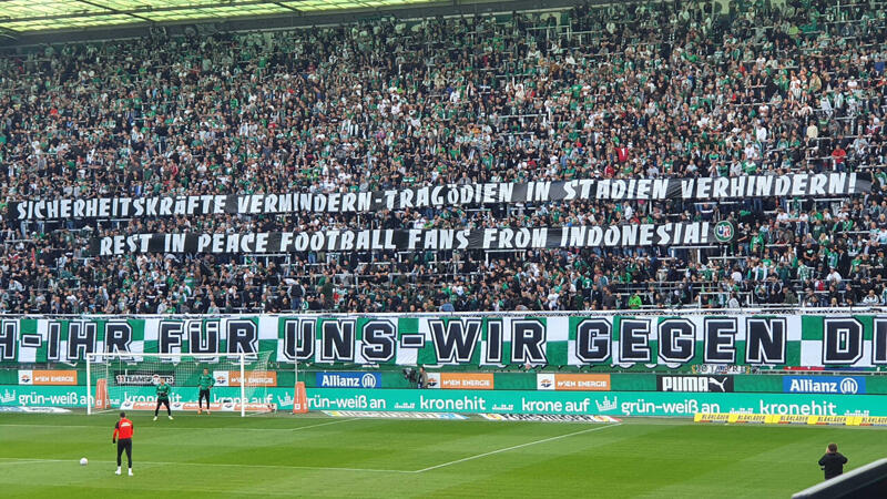 Rapid mit Fan-Banner für Indonesien-Opfer, gegen Polizei